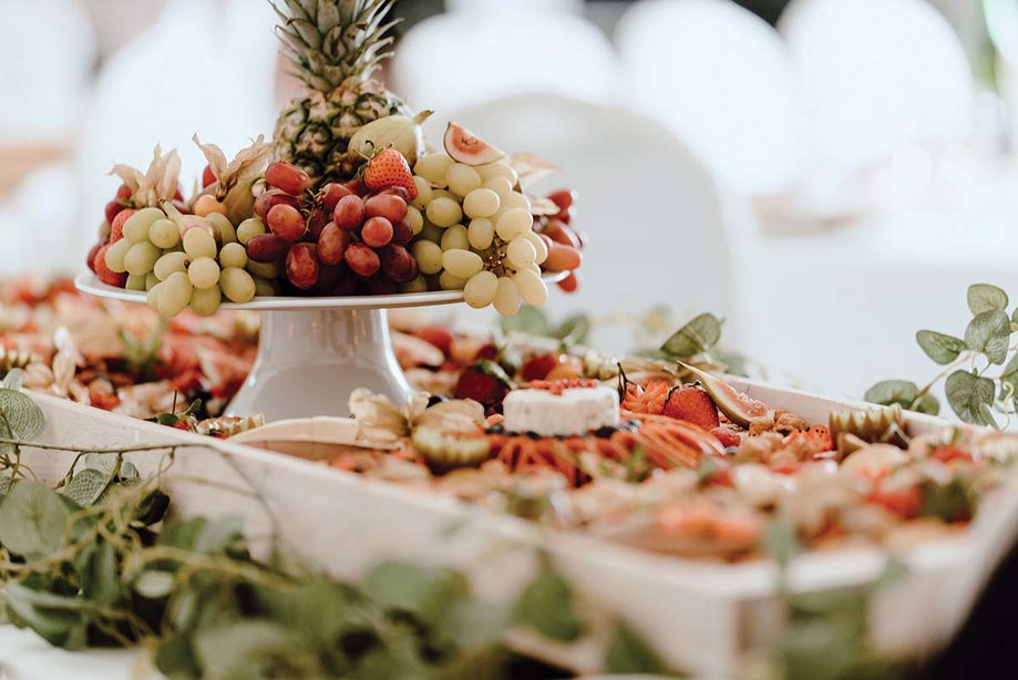 Grazing table with elevated display of grapes and pineapple decorated with eucalyptus